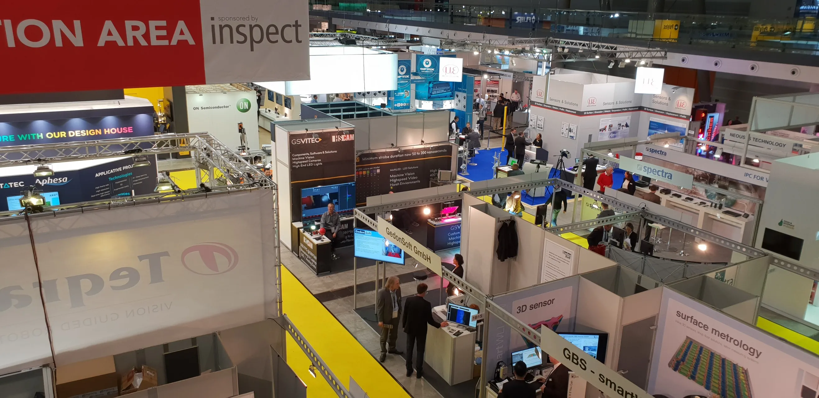 Elevated wide shot of the whole Messe Vision 2018 exhibition hall floor, with HSCAM's booth a small part of a much larger trade fair.