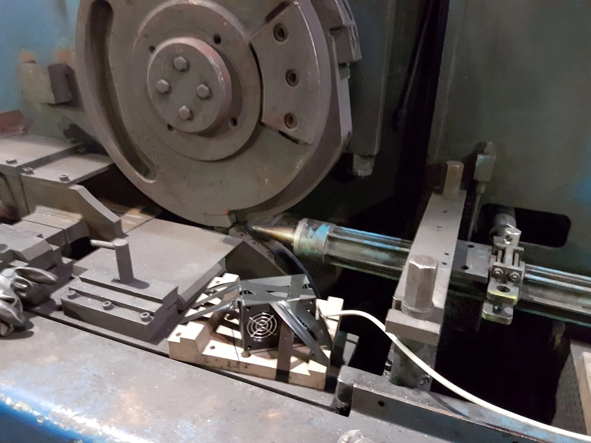 Close-up of a rolling-mill shear: the cutting disc, the wire guide tube and equipment with a cable below it.