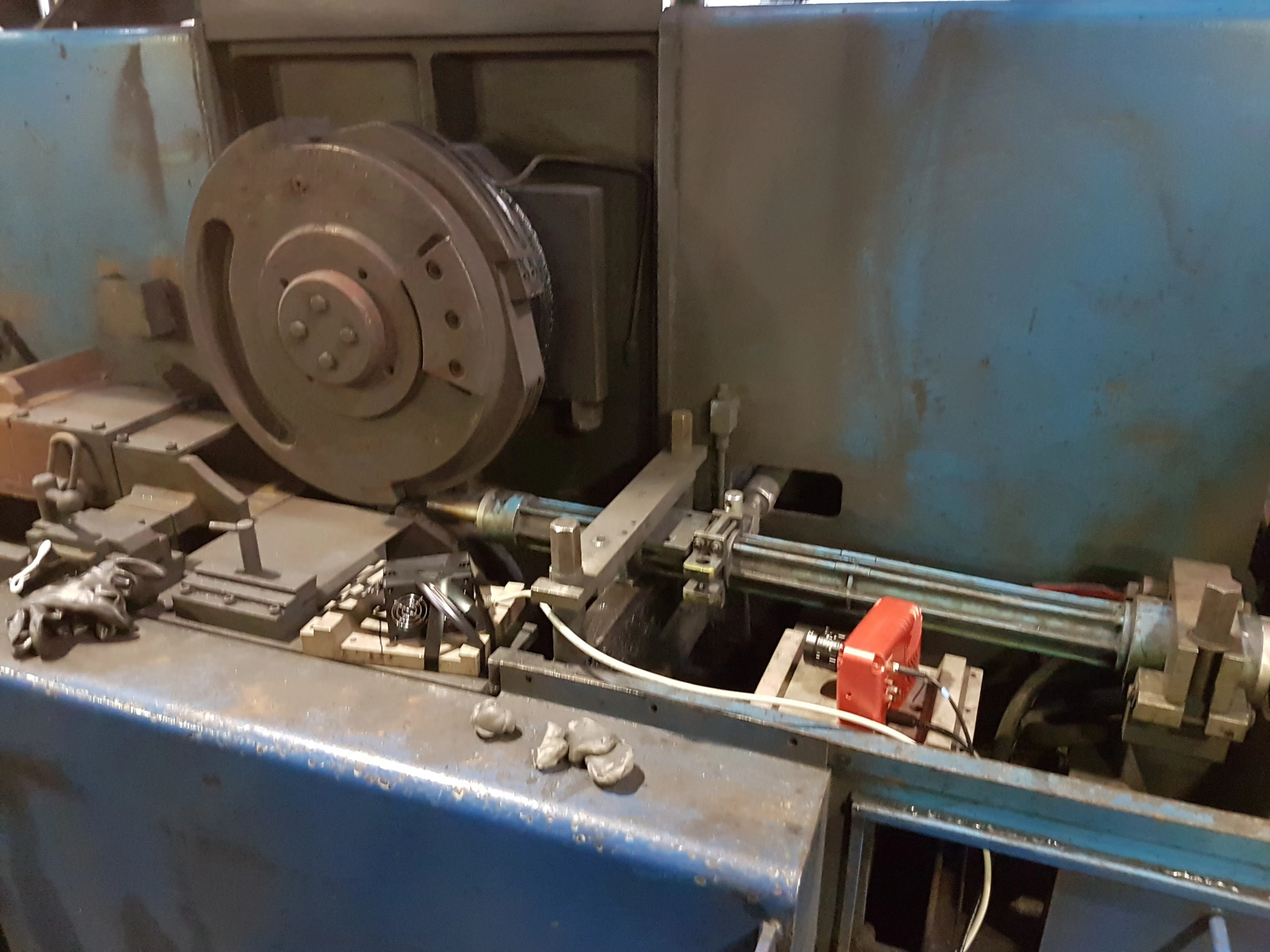 A red HSCAM camera mounted beside a rolling-mill shear, next to the cutting disc and wire guide tube.